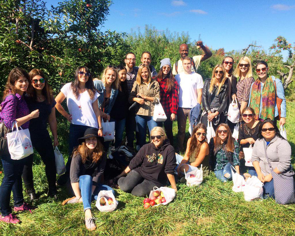 The crew of The Michael Alan Group poses with the apples they gathered at an orchard during MAG's annual Unplugged day.
